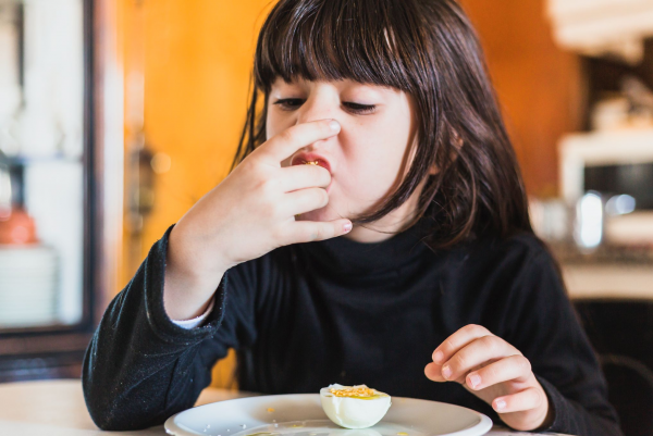 Seorang anak sedang makan telur
